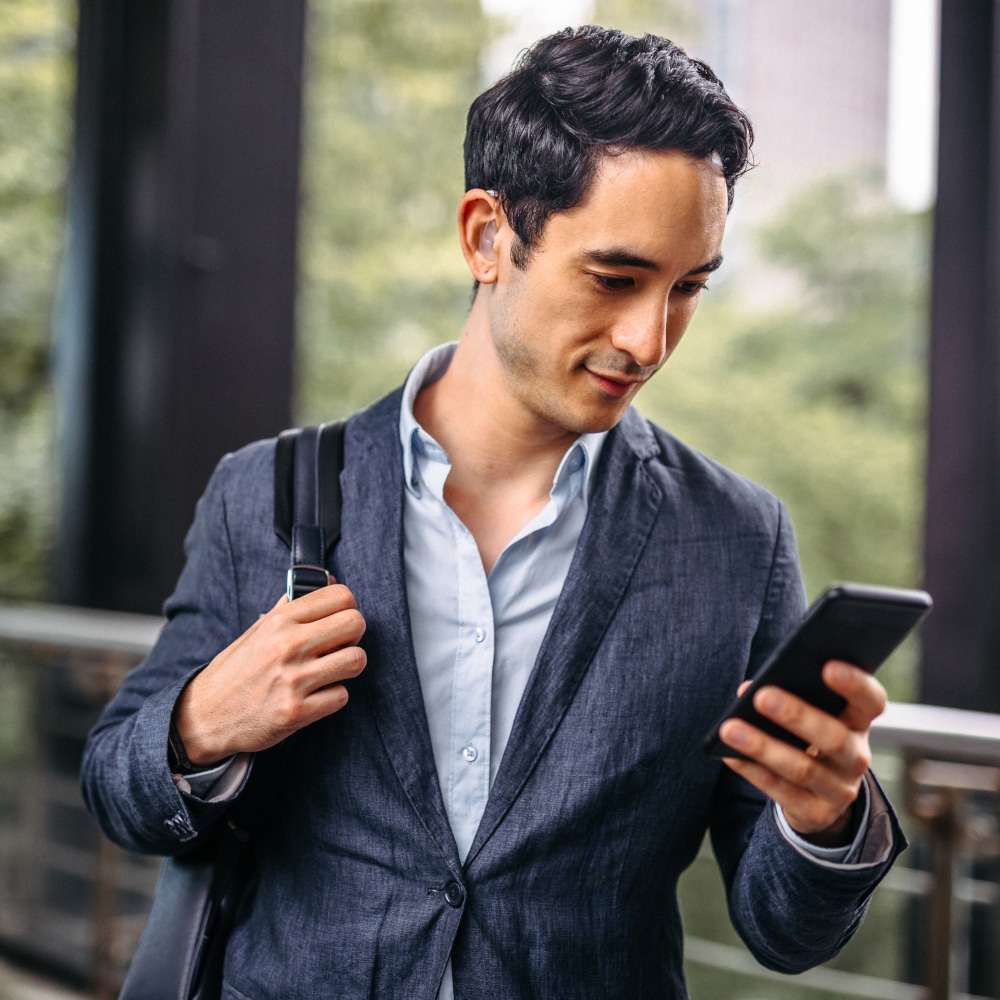 a business man with hearing aids on his phone