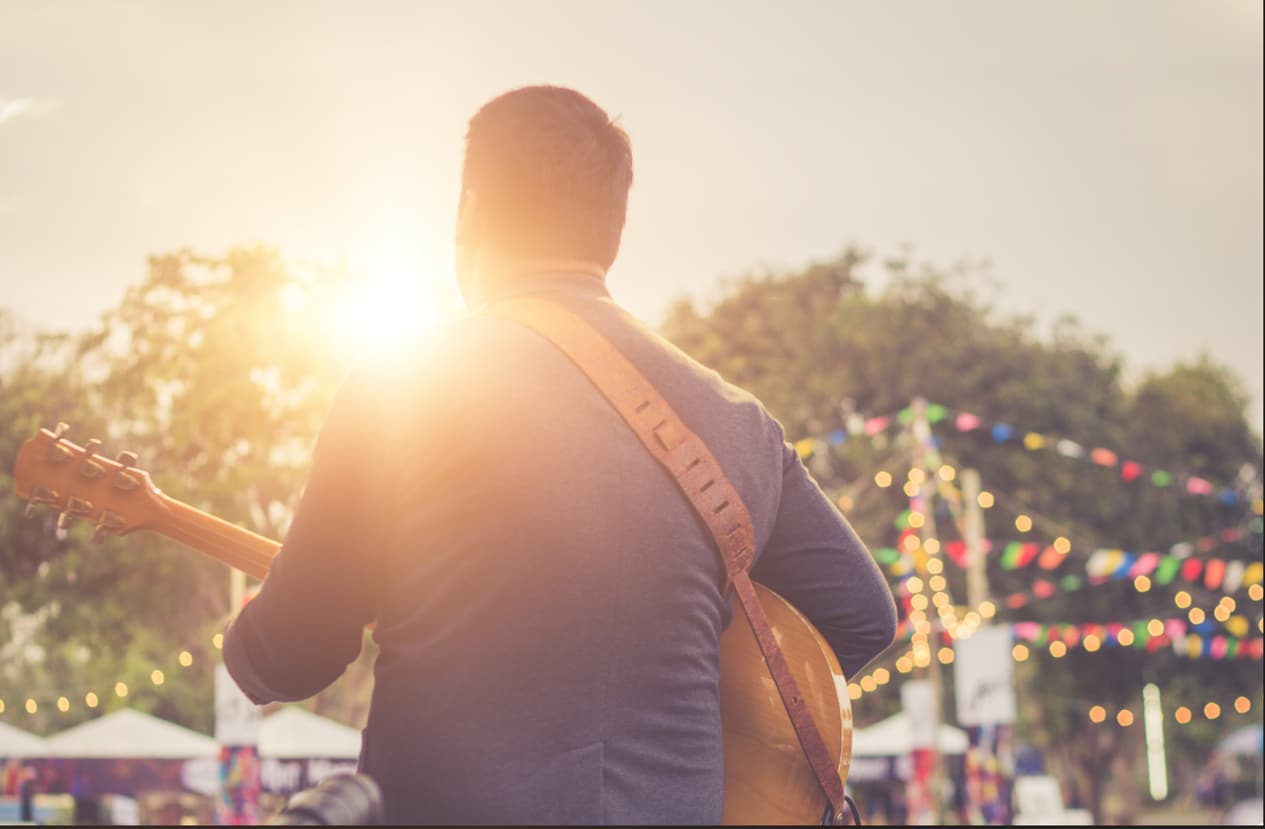 Musician playing at an outdoor music festival.