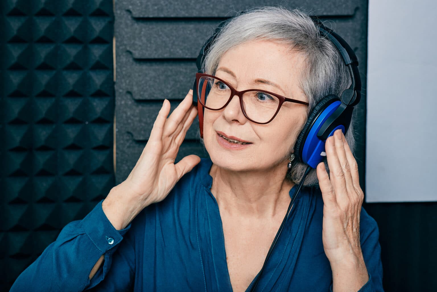 Senior woman wearing headphones while taking a hearing test.