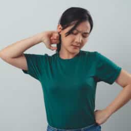 Woman with tinnitus holds ear