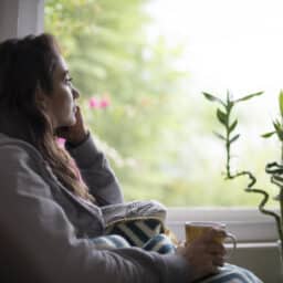 Woman looking out the window looking sad