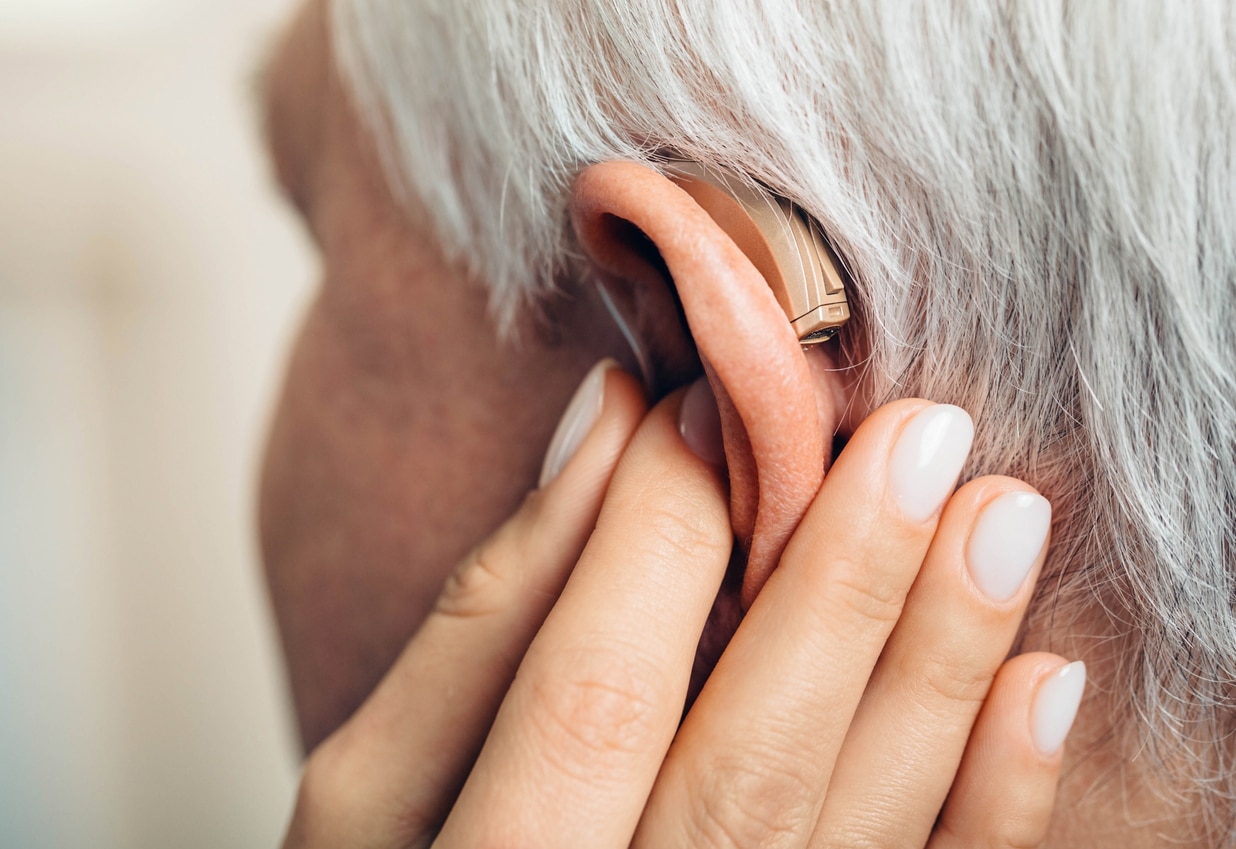 Audiologist examining hearing aid.