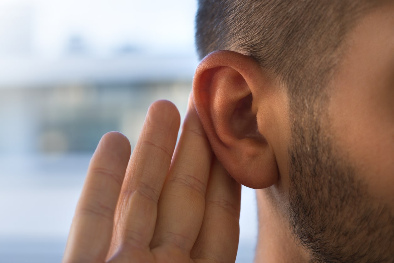 Close up hand to an ear.