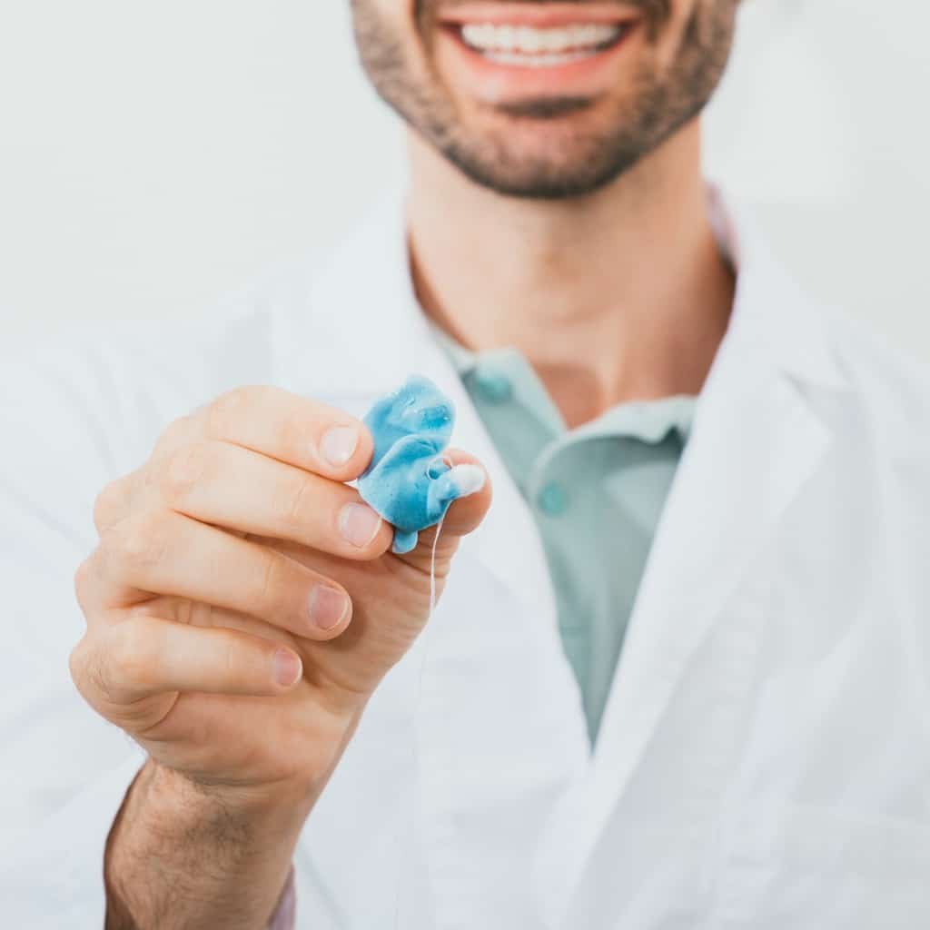 Audiologist holding a custom hearing aid.