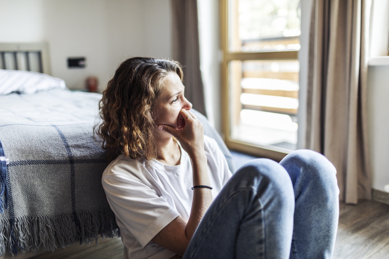 Woman with anxiety looking out the window.