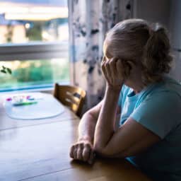 Lonely senior woman looking out the window